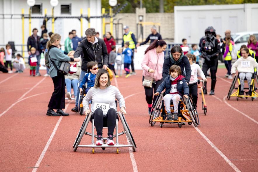 Concejal de deportes María Espín participando en la carrera con silla adaptada